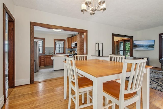 865 Harvard St, Rochester, NY 14610 - dining space with light wood-style floors, a chandelier, healthy amount of natural light, and baseboards