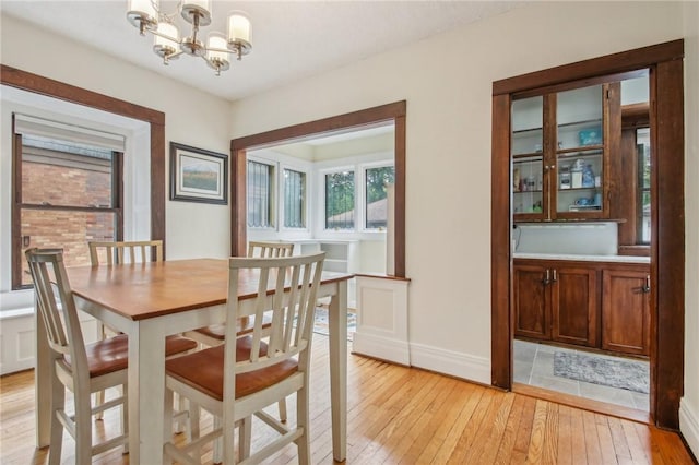 865 Harvard St, Rochester, NY 14610 - dining area featuring a chandelier, light wood-style floors, and baseboards