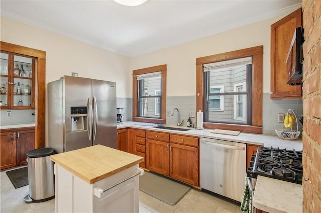 865 Harvard St, Rochester, NY 14610 - kitchen featuring appliances with stainless steel finishes, a sink, wooden counters, backsplash, and crown molding
