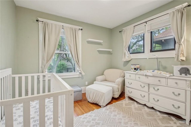 865 Harvard St, Rochester, NY 14610 - bedroom featuring multiple windows, a nursery area, and light wood-type flooring