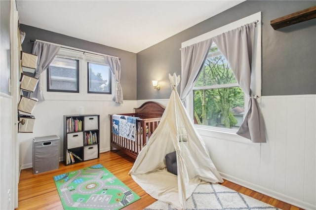 865 Harvard St, Rochester, NY 14610 - bedroom featuring wood finished floors, a nursery area, and wainscoting