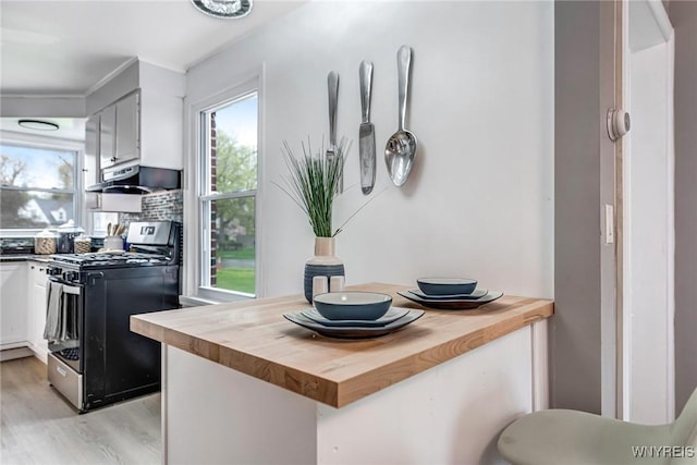 296 Burke Dr, Cheektowaga, NY 14215 - kitchen with gas range oven, butcher block counters, under cabinet range hood, and light wood-style floors