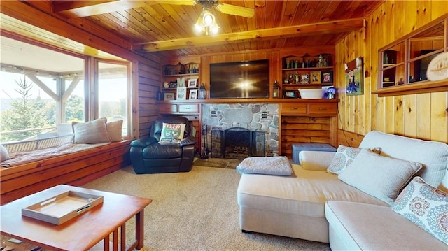 120 Fisher Ln, Afton, NY 13730 - carpeted living room featuring wood walls, wood ceiling with exposed beams, a fireplace, and a ceiling fan