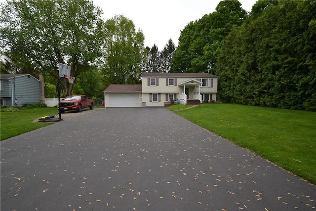 2314 Vandy Dr, Macedon, NY 14522 - view of front facade featuring an attached garage, asphalt driveway, a front yard, and view of wooded area