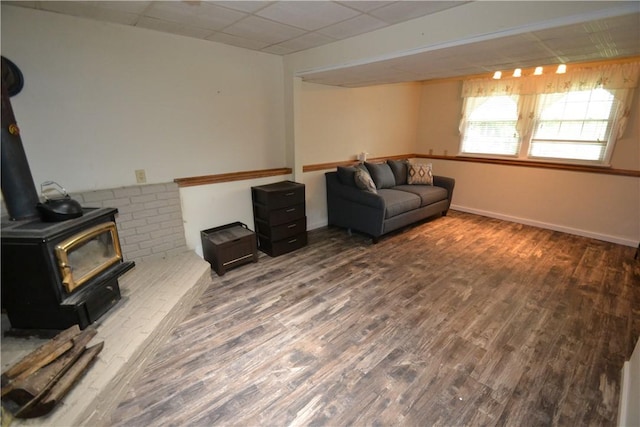 2314 Vandy Dr, Macedon, NY 14522 - living area with a wood stove, a paneled ceiling, wood finished floors, and baseboards