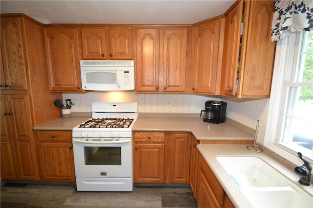 2314 Vandy Dr, Macedon, NY 14522 - kitchen featuring white appliances, backsplash, light countertops, and brown cabinetry