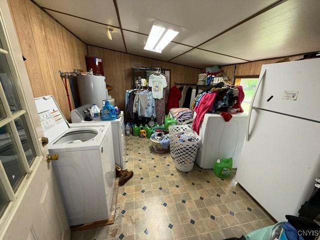 576 County Route 85, Granby, NY 13069 - below grade area featuring freestanding refrigerator, wooden walls, water heater, and independent washer and dryer