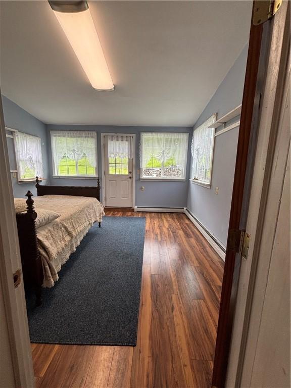 115 Depew Rd, Tioga, NY 13734 - bedroom with baseboard heating, lofted ceiling, and wood finished floors