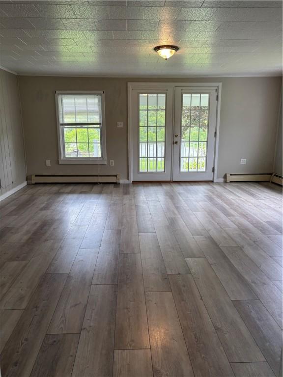 115 Depew Rd, Tioga, NY 13734 - unfurnished room with wood finished floors, baseboards, and a baseboard heating unit