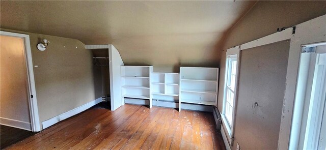 12034 Washington St, Wolcott, NY 14590 - unfurnished bedroom featuring hardwood / wood-style flooring, vaulted ceiling, multiple windows, baseboards, and a closet