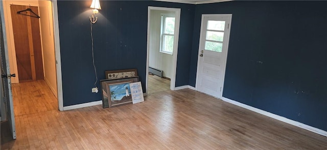 12034 Washington St, Wolcott, NY 14590 - foyer featuring baseboard heating, wood finished floors, crown molding, and baseboards