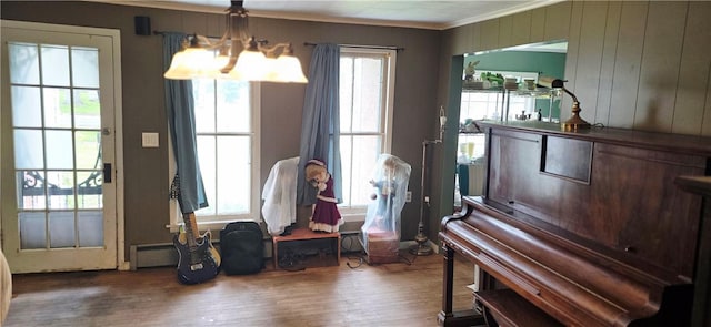 12034 Washington St, Wolcott, NY 14590 - living area with crown molding, wood finished floors, a baseboard radiator, and a chandelier
