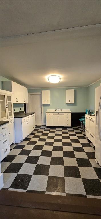 12034 Washington St, Wolcott, NY 14590 - kitchen featuring white cabinets, dark flooring, and a sink