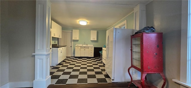 12034 Washington St, Wolcott, NY 14590 - kitchen with freestanding refrigerator, white cabinetry, dark floors, and ornate columns