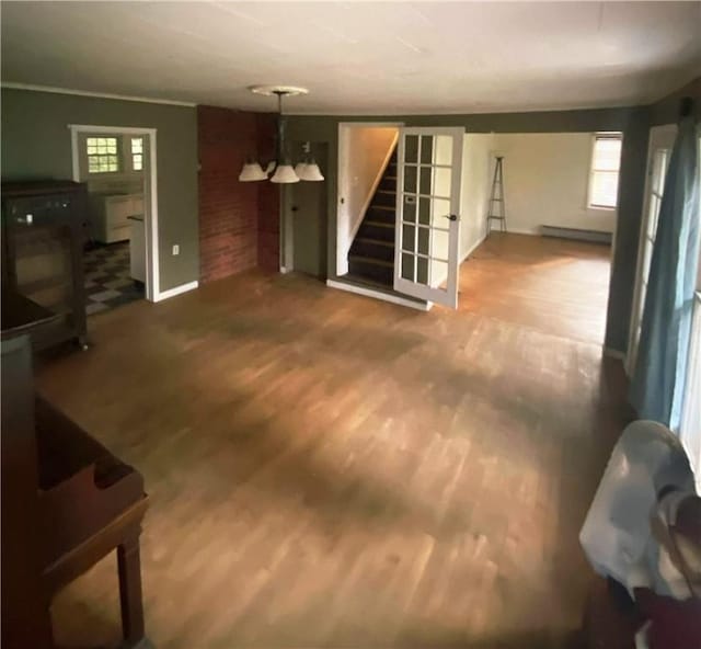 12034 Washington St, Wolcott, NY 14590 - unfurnished living room with stairs, wood finished floors, a baseboard heating unit, and baseboards
