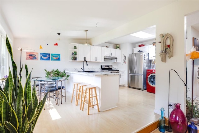 2804 Westinghouse Rd, Horseheads, NY 14845 - kitchen featuring stainless steel appliances, washer / dryer, a peninsula, under cabinet range hood, and open shelves