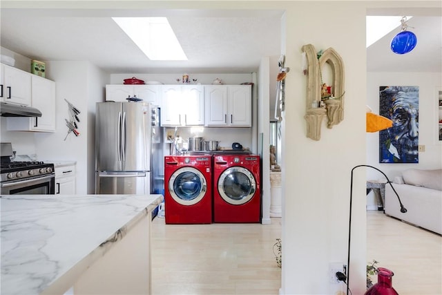 2804 Westinghouse Rd, Horseheads, NY 14845 - washroom with washing machine and clothes dryer, a skylight, and light wood-style floors