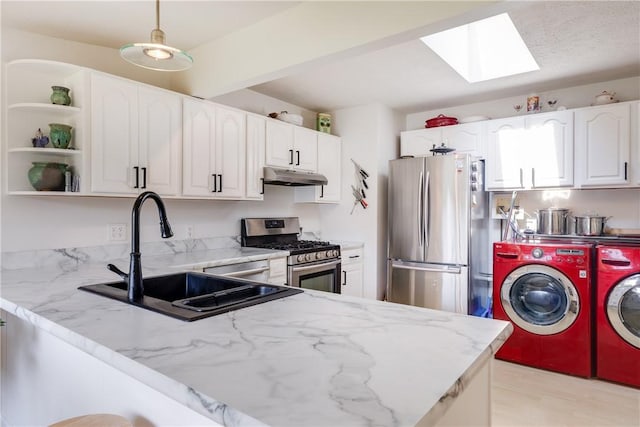 2804 Westinghouse Rd, Horseheads, NY 14845 - kitchen with appliances with stainless steel finishes, washing machine and dryer, under cabinet range hood, a skylight, and light stone countertops