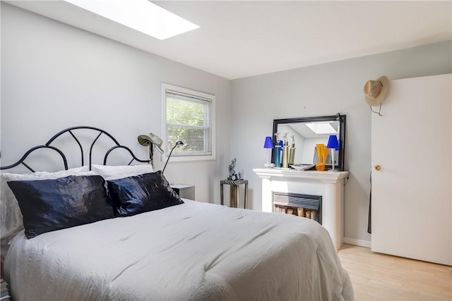 2804 Westinghouse Rd, Horseheads, NY 14845 - bedroom with light wood finished floors, a fireplace, and a skylight