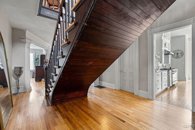 54 W 5th St, Oswego-City, NY 13126 - staircase with baseboards, wood-type flooring, lofted ceiling, wood ceiling, and ornate columns