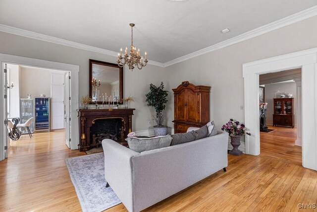 54 W 5th St, Oswego-City, NY 13126 - living room with crown molding, light wood-style flooring, a chandelier, and a fireplace