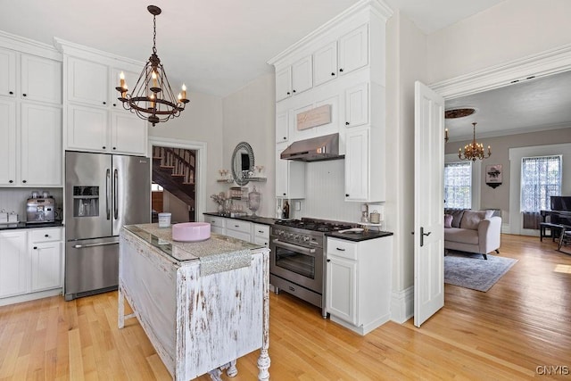 54 W 5th St, Oswego-City, NY 13126 - kitchen featuring stainless steel appliances, a chandelier, ventilation hood, light wood finished floors, and white cabinetry