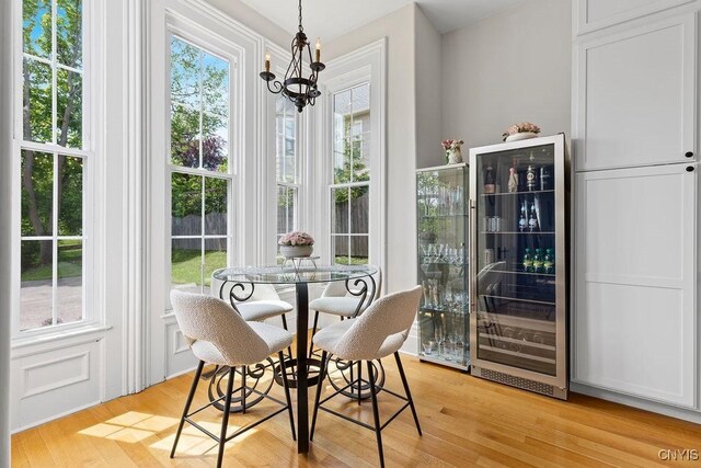54 W 5th St, Oswego-City, NY 13126 - dining area featuring wine cooler, a chandelier, and light wood-style flooring