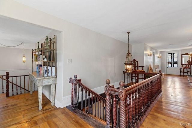 54 W 5th St, Oswego-City, NY 13126 - stairs with wood-type flooring, a chandelier, and baseboards
