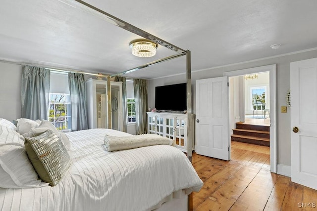 54 W 5th St, Oswego-City, NY 13126 - bedroom featuring multiple windows, a chandelier, and light wood-style flooring