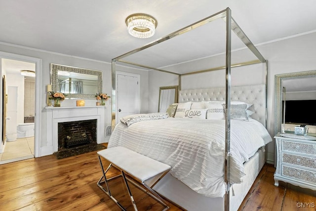 54 W 5th St, Oswego-City, NY 13126 - bedroom featuring hardwood / wood-style floors, crown molding, a fireplace with flush hearth, and ensuite bath