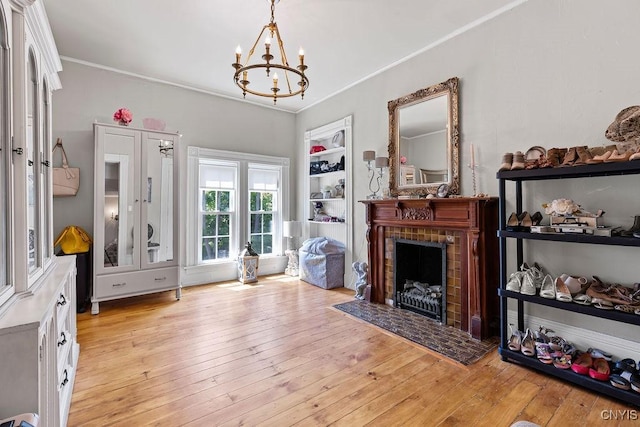 54 W 5th St, Oswego-City, NY 13126 - living area with a chandelier, a brick fireplace, crown molding, and light wood-type flooring