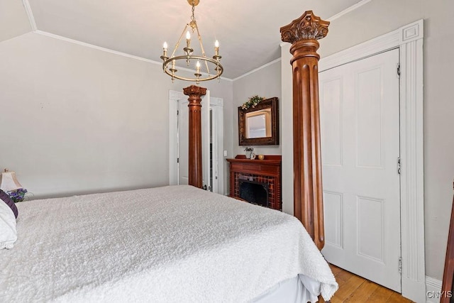 54 W 5th St, Oswego-City, NY 13126 - bedroom with a chandelier, crown molding, light wood-type flooring, a fireplace, and ornate columns