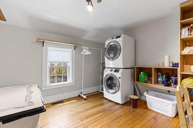 54 W 5th St, Oswego-City, NY 13126 - laundry room with stacked washer and clothes dryer and light wood-style flooring
