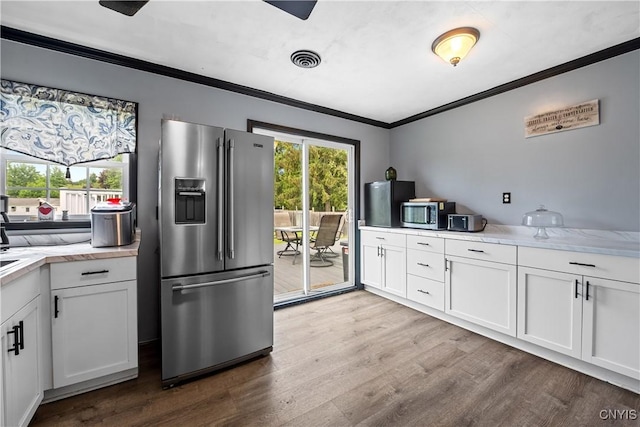 30 Bakeman St, Fulton, NY 13069 - kitchen with stainless steel appliances, crown molding, light countertops, wood finished floors, and white cabinets