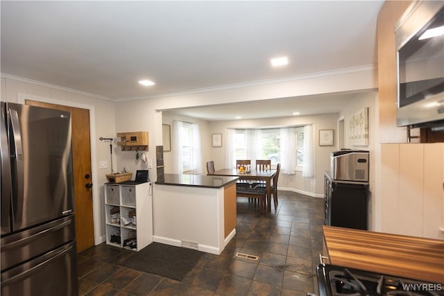 50 Cambria St, Lancaster, NY 14086 - kitchen with stainless steel appliances, a peninsula, dark countertops, crown molding, and baseboards