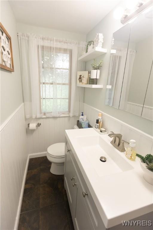 50 Cambria St, Lancaster, NY 14086 - bathroom featuring toilet, vanity, and a wainscoted wall