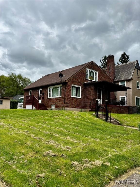 761 4th St, Niagara Falls, NY 14301 - view of side of property with a chimney, brick siding, and a yard