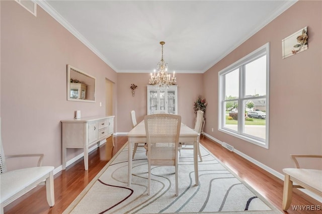 3906 Ontario Dr, Wheatfield, NY 14120 - dining space with a chandelier, wood finished floors, ornamental molding, and baseboards