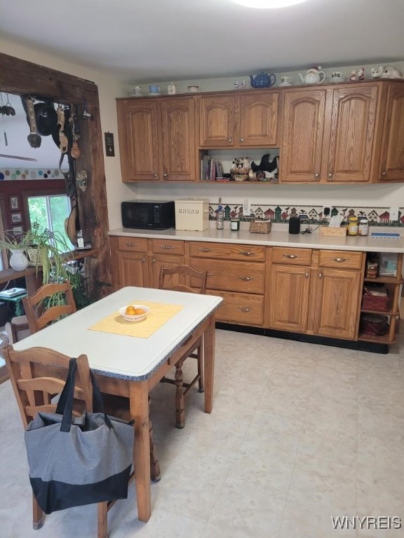 4368 State Route 19, Gainesville, NY 14550 - kitchen with black microwave, brown cabinets, light countertops, and open shelves