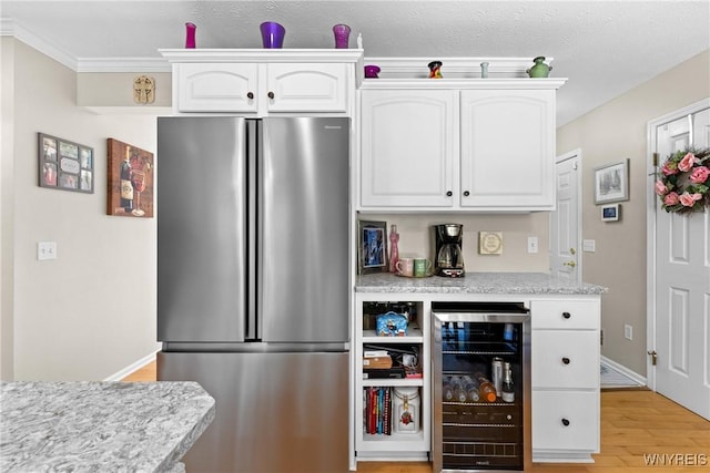 1660 Shallow Creek Trl, Webster, NY 14580 - kitchen featuring freestanding refrigerator, wine cooler, white cabinets, light wood-type flooring, and ornamental molding