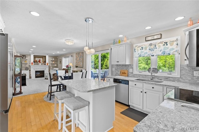 1660 Shallow Creek Trl, Webster, NY 14580 - kitchen featuring appliances with stainless steel finishes, a sink, a kitchen island, white cabinetry, and recessed lighting
