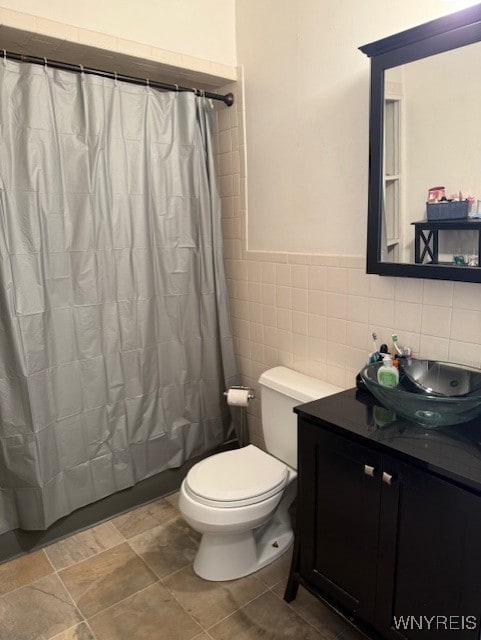 244 Parkwood Ave, Tonawanda-Town, NY 14217 - full bath featuring vanity, toilet, tile walls, curtained shower, and a wainscoted wall