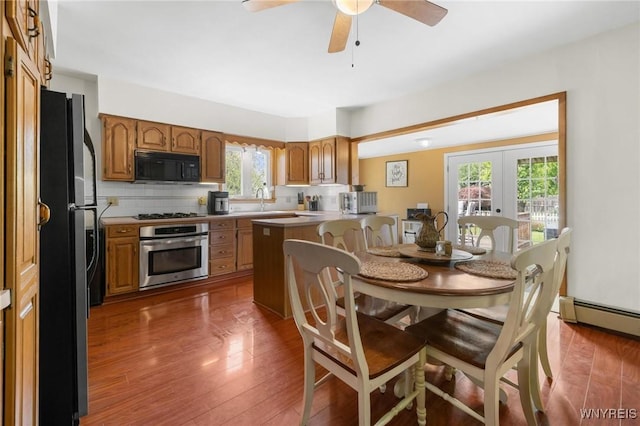 2654 Main St, Newfane, NY 14108 - dining space featuring french doors, wood finished floors, a ceiling fan, and a baseboard radiator