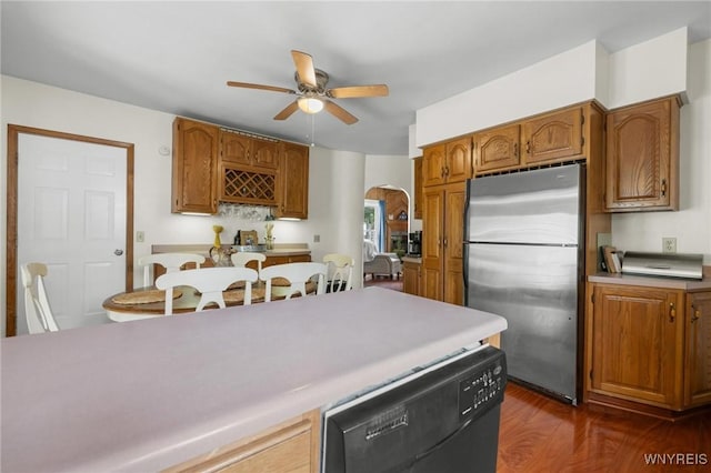 2654 Main St, Newfane, NY 14108 - kitchen with freestanding refrigerator, dishwashing machine, arched walkways, a ceiling fan, and dark wood finished floors