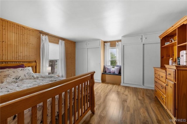 2654 Main St, Newfane, NY 14108 - bedroom with two closets, multiple windows, wood finished floors, and wood walls