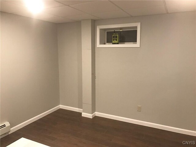 47089 County Route 100, Alexandria, NY 13640 - finished below grade area featuring baseboards, dark wood finished floors, a baseboard radiator, and a drop ceiling