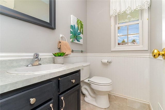 65 Geraldine Pkwy, Gates, NY 14624 - bathroom with vanity, toilet, wainscoting, and tile patterned flooring