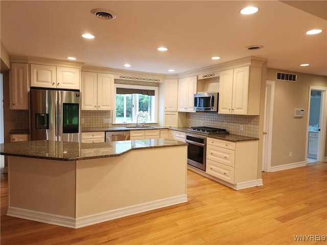 6731 Chestnut Ridge Rd, Orchard Park, NY 14127 - kitchen with stainless steel appliances, a sink, light wood-style flooring, a center island, and white cabinets