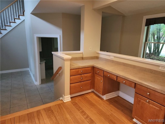6731 Chestnut Ridge Rd, Orchard Park, NY 14127 - kitchen featuring brown cabinetry, light countertops, light wood-style floors, and baseboards