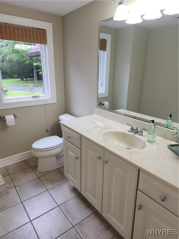 6731 Chestnut Ridge Rd, Orchard Park, NY 14127 - half bathroom featuring toilet, vanity, tile patterned floors, and baseboards
